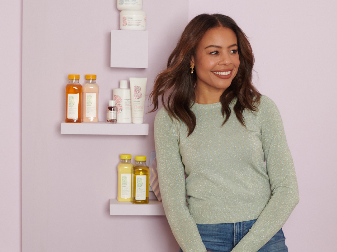 Nancy Twine being intentional about her career, standing against a wall of Briogeo products