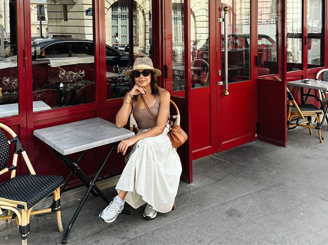 Nancy Twine sitting at a restaurant table on her trip to Paris in the summer and planning to write a travel guide