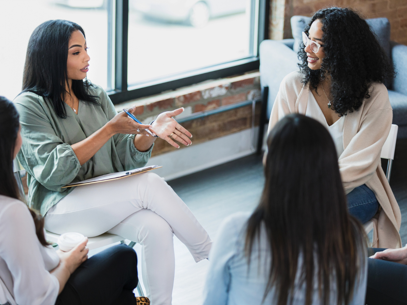 A diverse group of female entrepreneurs sitting in a circle, networking and building connections for their business growth.